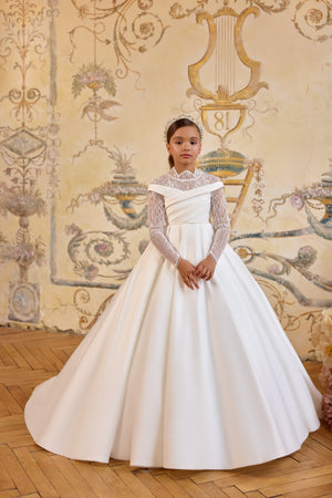 Gabriela luxury First Communion gown with illusion lace bodice, off-the-shoulder neckline, oversized bow, and cathedral-length satin train.